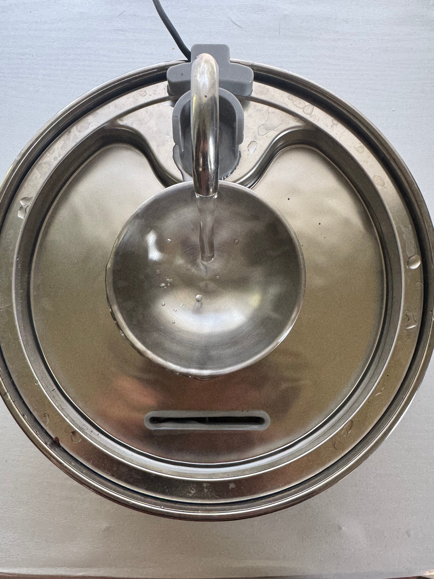 Top-down view of the Dripurr fountain showing the multi-bowl stainless steel layout