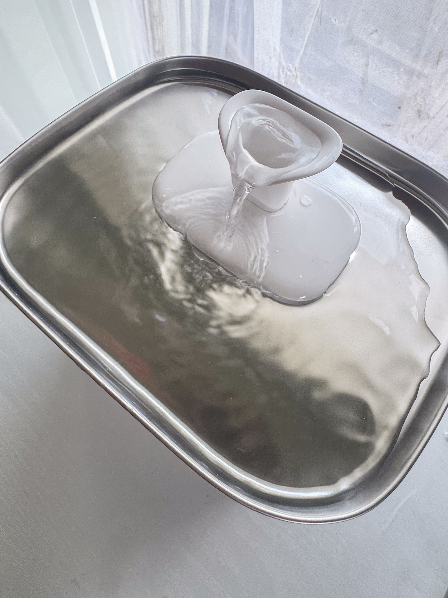 Top-down view of the PETLIBRO fountain showing the dual-spout water flow